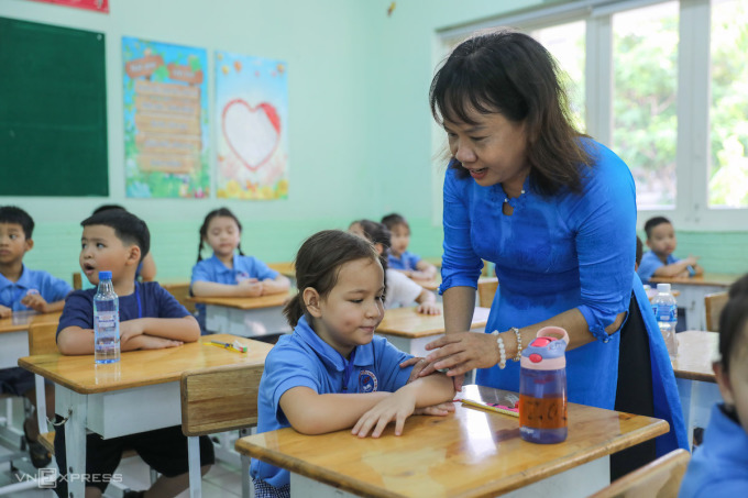 Giáo viên trường tiểu học Đinh Tiên Hoàng (TP HCM) hướng dẫn học sinh lớp 1 trong ngày đầu đến trường hôm 22/8/2022. Ảnh: Quỳnh Trần